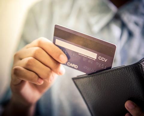 picture of a credit card being placed in a wallet 